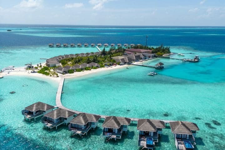 Vista aérea de una isla con resort y bungalows sobre el mar en Maldivas