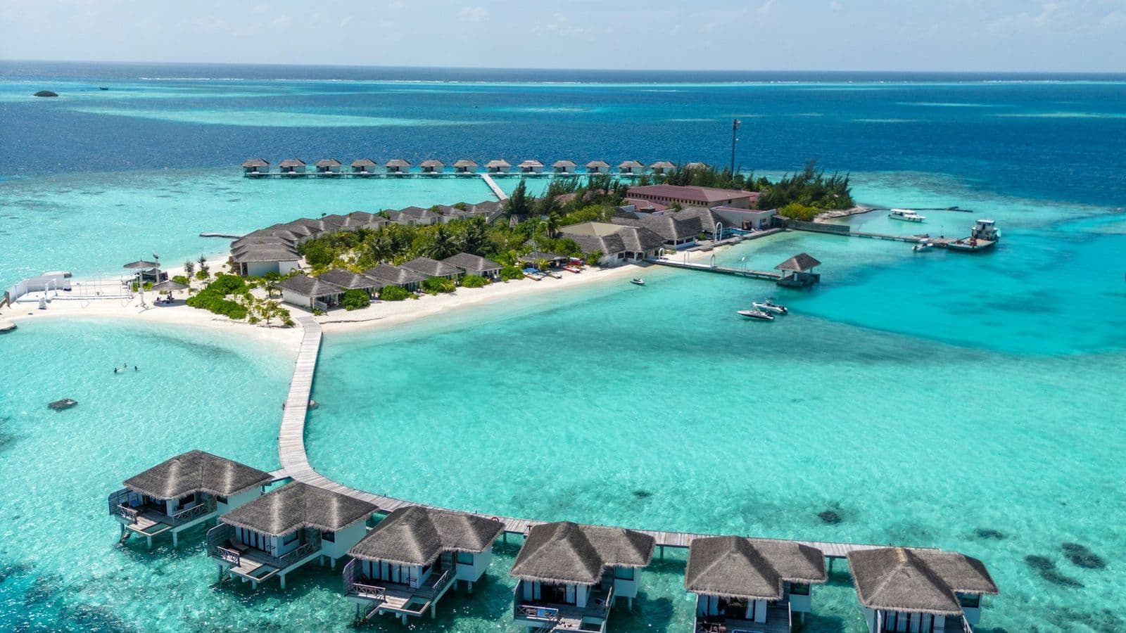 Vista aérea de una isla con resort y bungalows sobre el mar en Maldivas